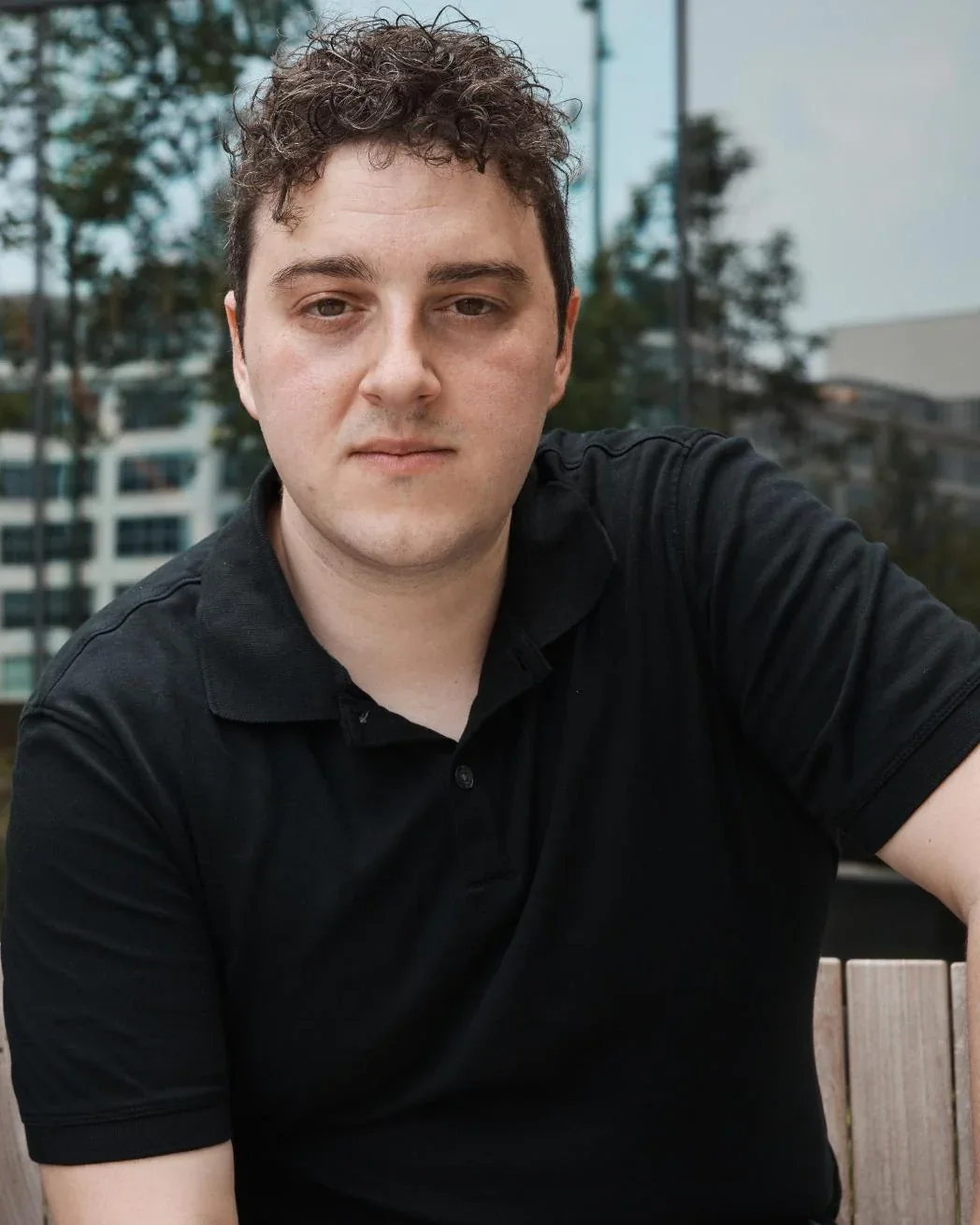 Ryan M. DeRosa in a black polo, looking into the lens